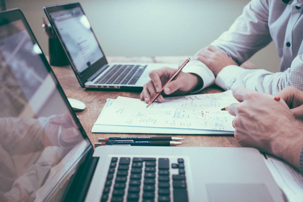 Business planning documents and charts on a desk, representing the build-versus-buy decision