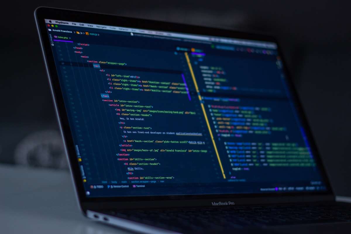 Programmer's screen filled with source code in a dark room
